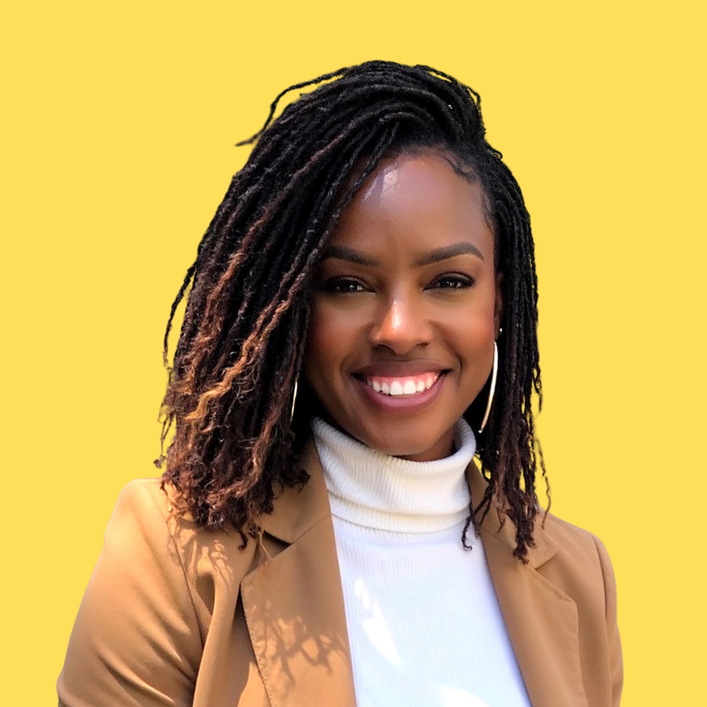 Kanetria, M.Ed., founder of The Little Seed Education Systems, smiling in a camel blazer and white turtleneck